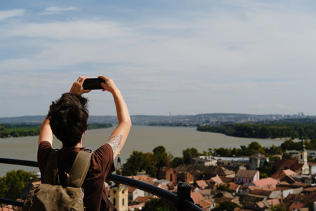 Female traveler photographing the Danube River and Belgrade skyline from Gardos Tower in Zemun. Travel blogger making video outdoorの写真素材
