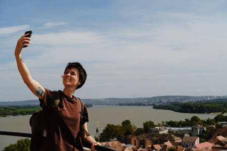 Woman taking selfie with the Danube River and Belgrade cityscape in the background from Gardos...