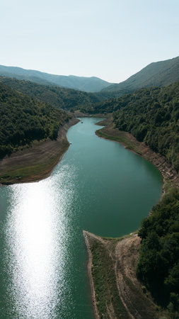 Aerial view of Zavoj Lake in Stara Planina National Park, Serbia, with turquoise water reflecting...