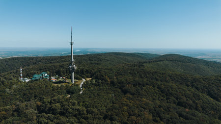 Aerial view of TV tower Iriski Venac rising above the forested hills of Fruska Gora National Park...