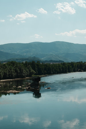 Famous Drina River House on a rock in the middle of the Drina River, near Bajina Basta, Serbia, surrounded by calm water and forested mountainsの写真素材