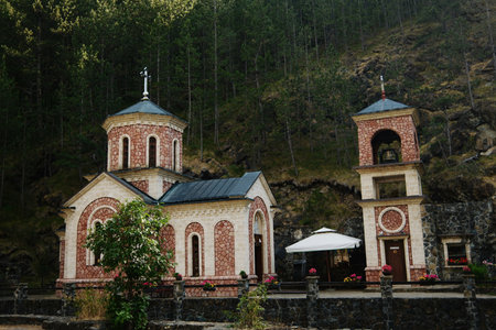 Orthodox church Bele Vode and bell tower in Mokra Gora, Serbia, surrounded by nature and forest hillsの写真素材