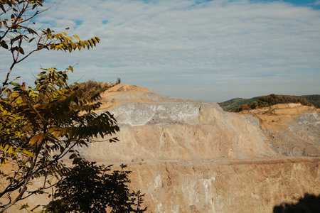 View of rocky quarry slopes and forested hills under cloudy autumn sky in Fruska Gora National Park Serbiaの写真素材