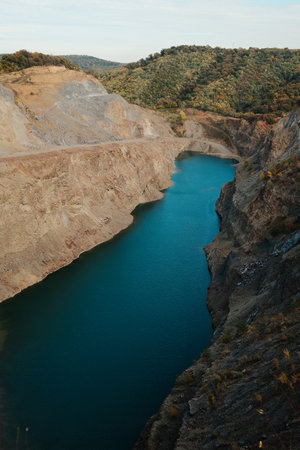 Scenic view of blue water lake in rocky quarry surrounded by colorful autumn forest and hills in Fruska Gora Serbiaの写真素材