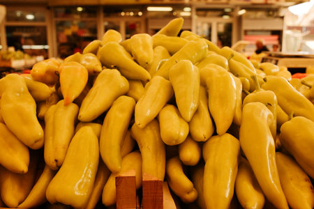 Fresh yellow peppers piled on a market stand. Natural healthy vegetables symbolizing freshness and organic farmingの写真素材