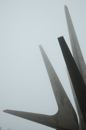 Minimalist composition showing the pointed shapes of the Kosmaj Monument disappearing into thick fogの写真素材