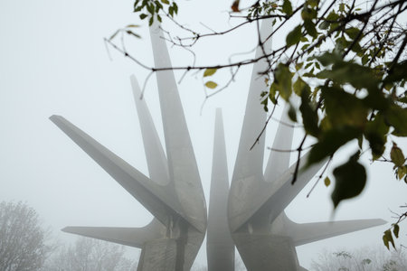 View of the Kosmaj Monument framed by autumn foliage and soft fog, creating a serene and mystical moodの写真素材
