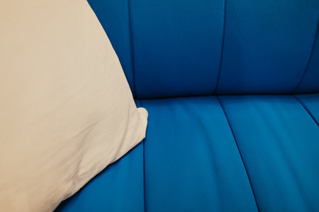 Close-up of a soft blue sofa with a white pillow, simple and clean modern interior design conceptの写真素材
