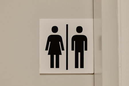 Simple black unisex restroom sign on a neutral wall. The concept represents clarity, universal design, and gender equalityの写真素材