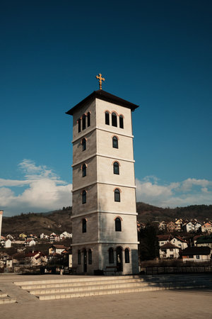 Tall stone bell tower rising above Andricgrad in Visegrad, Bosnia and Herzegovina. Vertical structure represents tradition, religion, and historical continuityの写真素材
