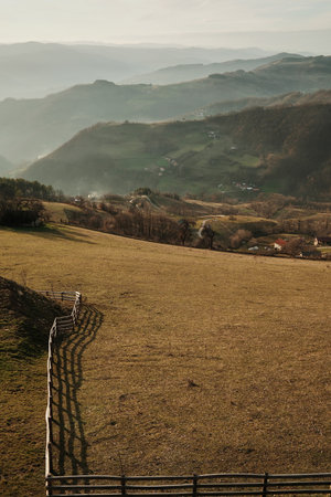 Open meadow with wooden fence overlooking layered hills and valleys in Tara region, Serbia. Concept...