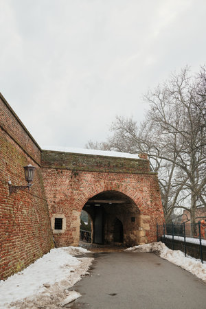 Brick fortress entrance in Kalemegdan, Belgrade with arched passage and winter path, highlighting medieval military architecture and historic urban landscapeの写真素材