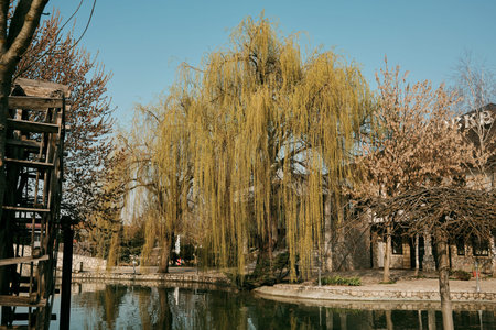 Traditional wooden watermill with large wheel above calm pond in Stanisici Ethno Village, Bosnia and Herzegovina. Concept of rural heritage, historic technology and Balkan tourism