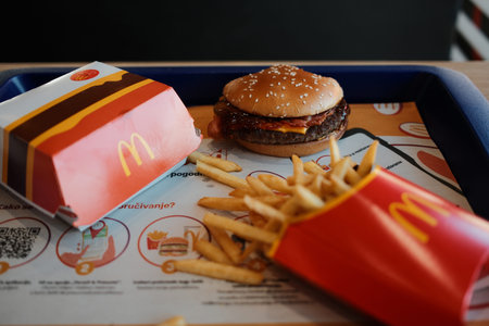 Burger with bacon and cheese served with french fries on tray inside McDonalds restaurant interior. Concept of global fast food chain meal. Belgrade, Serbia - 28 February 2026