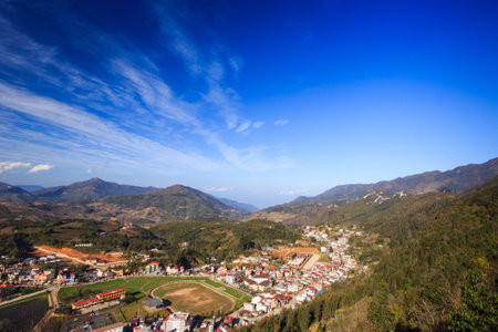 Aerial view of clusters of buildings nestled in the green valley of Sapa, Vietnamの写真素材