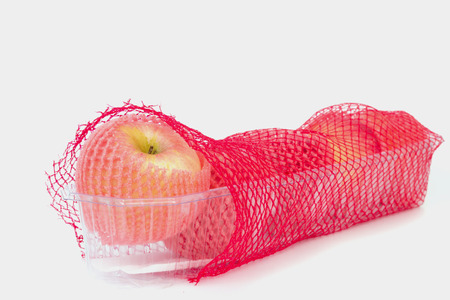 Apples wrapped in the red shopping netの写真素材
