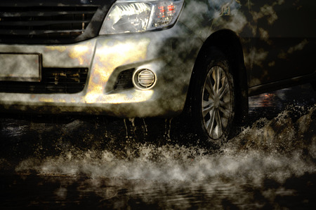 water splash with car on flooded road after rainsの写真素材