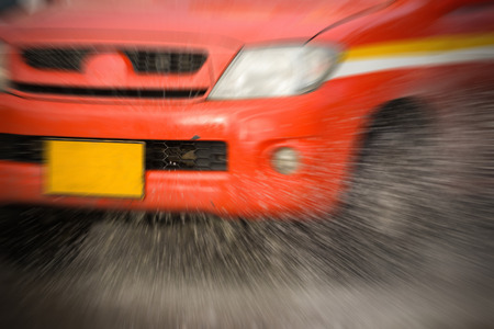 water splash with car on flooded road after rainsの写真素材