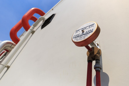 red sprinkler fire alarm bell set on dirty wallの写真素材