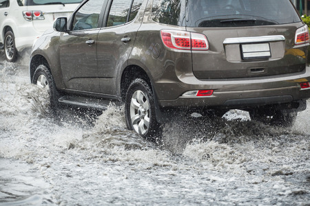 Splash by a car as it goes through flood waterの写真素材