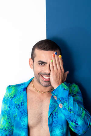 happy young gay man smiling at camera, rainbow painted nails, gay man looking at camera and smiling,の写真素材