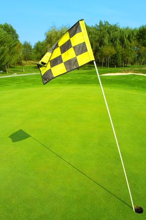 Golf flag on a green in the morningの写真素材
