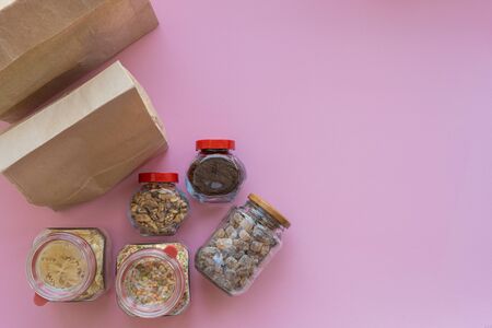 Different food with paper bags on a pink background, donation concept