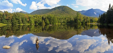 Panoramic view of Phelps Mtn, Mt Marcy and Mt. Colden reflected in Marcy Dam Pond in the High Peaks region of the Adirondack Mountains of New Yorkの写真素材