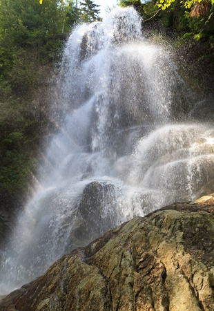 Shafts of sunlight illuminate the spray at Beaver Meadow Falls in the Adirondack State Park in New Yorkの写真素材