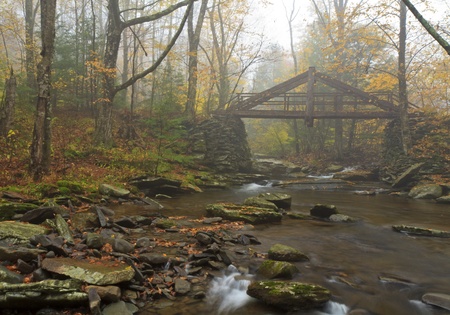 A hand-hewn bridge over a stream in foggy Platte's Clove in the Catskills Mountains of New Yorkの写真素材