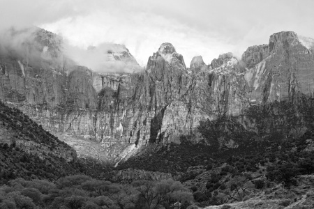 Black and white image of the Towers of the Virgin peaks shrouded in early morning clouds in  Zion National Park, Utahの写真素材