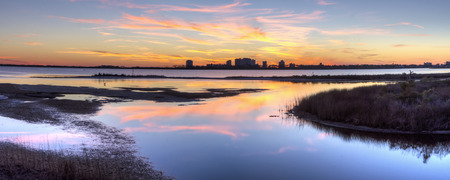 A colorful sunset reflected in the inlet at Big lagoon State Park, with Perdido Key, Floridaの写真素材