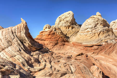 Twisty and curving rocks look like ice cream in the unique and remote White Pocket rock formations in Vermillion Cliffs National Monument in Arizona.の写真素材
