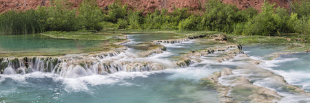 The crystal clear turquoise waters of Havasu Creek flow over travertine terraces forming pools in Havasupai Indian Reservation, Arizona.の写真素材