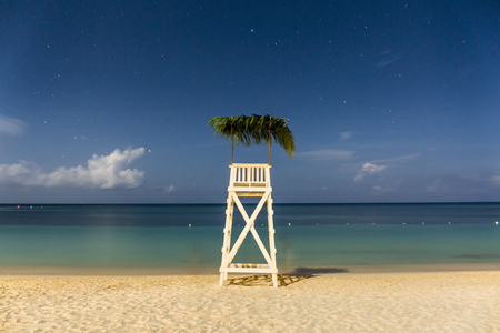 A full moon lights upa lifeguard perch on the beach in West Bay, Roatan, Honduras.の写真素材