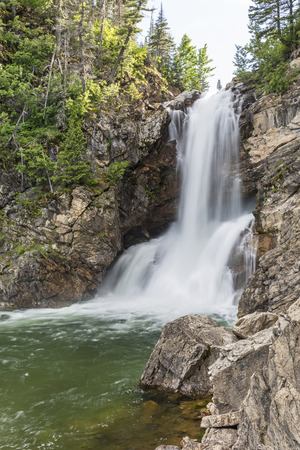 Running Eagle Falls, or Trick Falls, falls in two sections, with some water flowing over and some flowing through a cavern, in the Two Medicine area of Glacier National Park, Montana.の写真素材