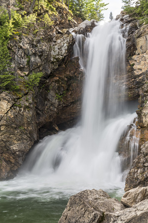 Running Eagle Falls, or Trick Falls, falls in two sections, with some water flowing over and some flowing through a cavern, in the Two Medicine area of Glacier National Park, Montana.の写真素材