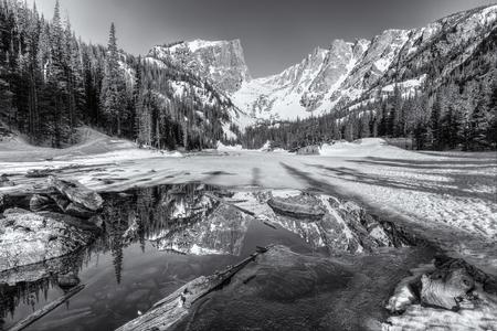 Morning Sun on Hallett Peak is reflected in half frozen Dream Lake in Rocky Mountain National Park, Coloradoの写真素材