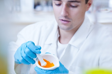 close-up portrait of a young male researcher carrying out experiments in a research lab/laboratoryの写真素材