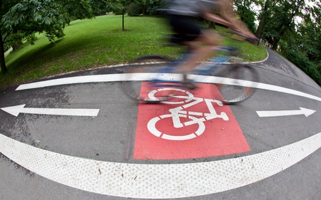 biker on a biking path in a city park (motion blur is used to convey movement)の写真素材