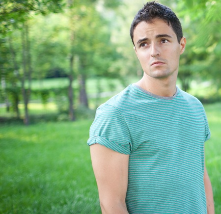 Portrait of a handsome young man while outdoors in a park on a lovely summer dayの写真素材