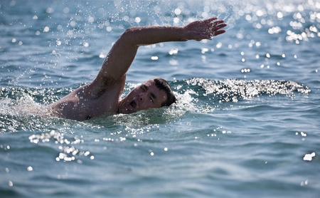 young male swimmer swimming in the sea/oceanの写真素材