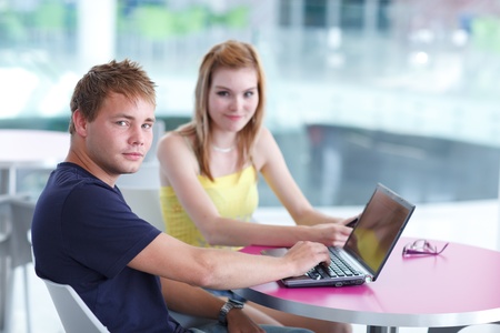 two college students having fun studying together, using a laptop computer (shallow DOF, color toned...