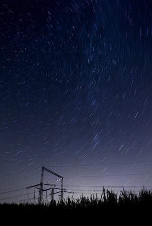 starry night landscape with high voltage polesの写真素材