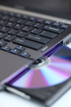 Closeup view of a modern high-end laptop computer with its CD/DVD optical drive open (shallow DOF) 
