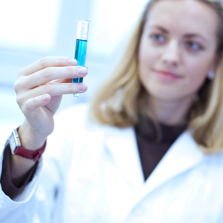 Portrait of a pretty female researcher carrying out research experiments in a lab