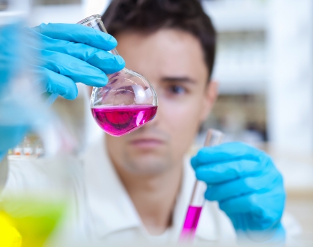 young male researcher carrying out scientific research in a lab young male researcher carrying out scientific research in a lab