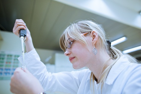 female researcher carrying out research experiments in a chemistry lab (color toned image)の写真素材