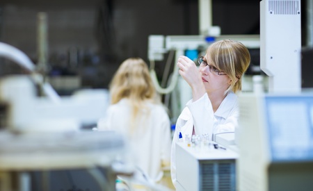portrait of a female researcher carrying out research in a chemistry lab (color toned image; shallow...