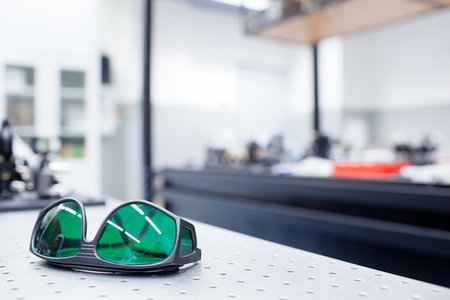 quantum optics lab - shallow DOF; selective focus on the protective goggles in the foreground (color toned image)の写真素材